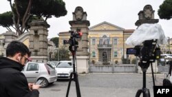 FILE - A reporter waits outside the Lazzaro Spallanzani National Institute for Infectious Diseases in Rome, Jan. 31, 2020, where two Chinese tourists who had tested positive for the coronavirus were being held in isolation.