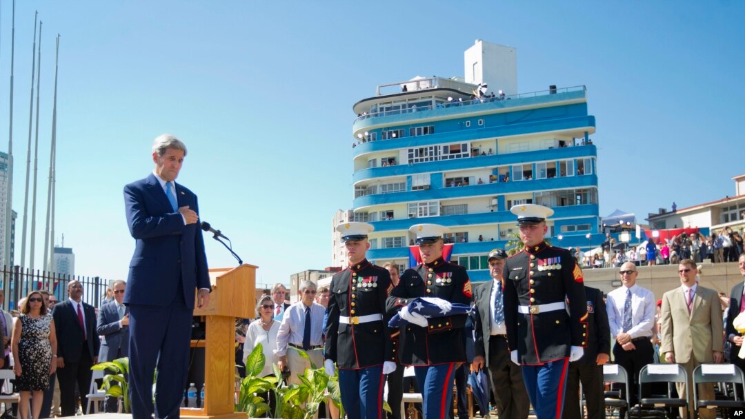 Secretary of State John Kerry watches as U.S. Marines, stationed in Cuba carry the American flag during the raising of the U.S. flag over the newly reopened embassy in Havana, Cuba. Aug. 14, 2015. 