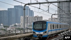 A train of the Line 1 of the HCMC Metro is seen past residential buildings in Ho Chi Minh City on Dec. 22, 2024.