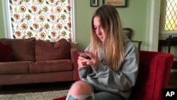 In this Nov. 1, 2018 photo, Laurel Foster holds her phone in San Francisco. Foster is among teens involved in Stanford University research testing whether smartphones can be used to help detect depression and potential self-harm. (AP Photo/Haven Daley)