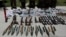 Weapons and ammunition seized are presented to the media along with insurgents suspected of being from the Haqqani network at the National Directorate of Security (NDS) headquarters in Kabul, May 30, 2013. 