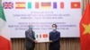 FILE - Vietnam's Deputy Foreign Minister To Anh Dung (right) hands a box of protective masks to Italy's Ambassador to Vietnam Antonio Alessandro during a handover ceremony as Vietnam donated supplies to European countries, in Hanoi, Vietnam, April 7, 2020.