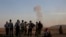 Turkish Kurds watch as airstrikes hit Kobani, inside Syria, as fighting intensifies between Syrian Kurds and the militants of Islamic State group, in Mursitpinar, on the outskirts of Suruc, at the Turkey-Syria border, Wednesday, Oct. 8, 2014.