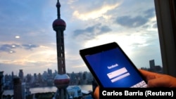 Seorang pria membuka laman Facebook di iPadnya di distrik keuangan Pudong di Shanghai, China, 25 September 2013. (Foto: Carlos Barria/Reuters)