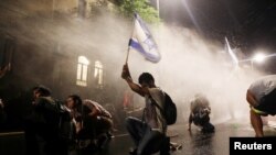 이스라엘 예루살렘에서 경찰들이 베냐민 네타냐후 이스라엘 총리의 연립정부에 반대하는 시위대를 향해 물대포를 쏘고 있다. 