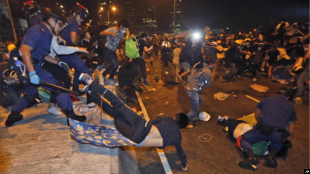 Polisi Hong Kong berusaha membersihkan para demonstran yang memblokade jalanan di Hong Kong (1/12). 