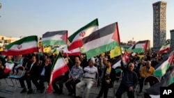 在伊朗德黑蘭市中心廣場上，伊朗示威者手持伊朗、巴勒斯坦和黎巴嫩真主黨的旗幟舉行聲援巴勒斯坦的集會。（2023年11月3日）