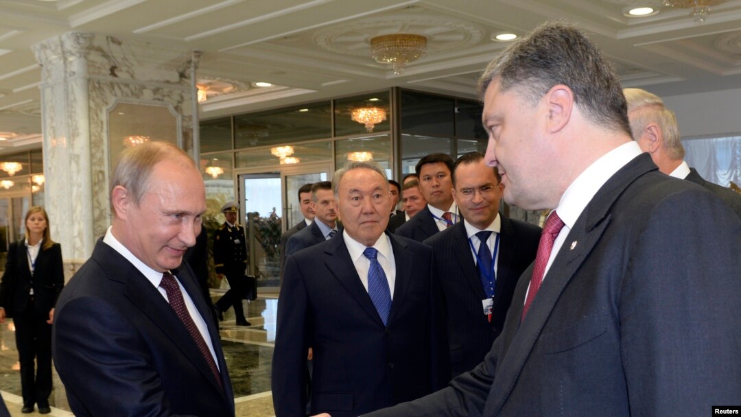 Presiden Rusia Vladimir Putin (kiri) berjabat tangan dengan Presiden Ukraina Petro Poroshenko di Minsk, Belarusia, 26 Agt 2014.