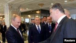 Presiden Rusia Vladimir Putin (kiri) berjabat tangan dengan Presiden Ukraina Petro Poroshenko di Minsk, Belarusia, 26 Agt 2014.