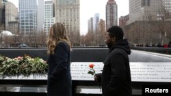 FILE - Attendees wait to leave roses during a commemoration ceremony of the 25th anniversary of the 1993 World Trade Center bombing at the north reflecting pool of the National September 11 Memorial & Museum at the World Trade Center site in the Manhattan borough of New York, Feb. 26, 2018. 