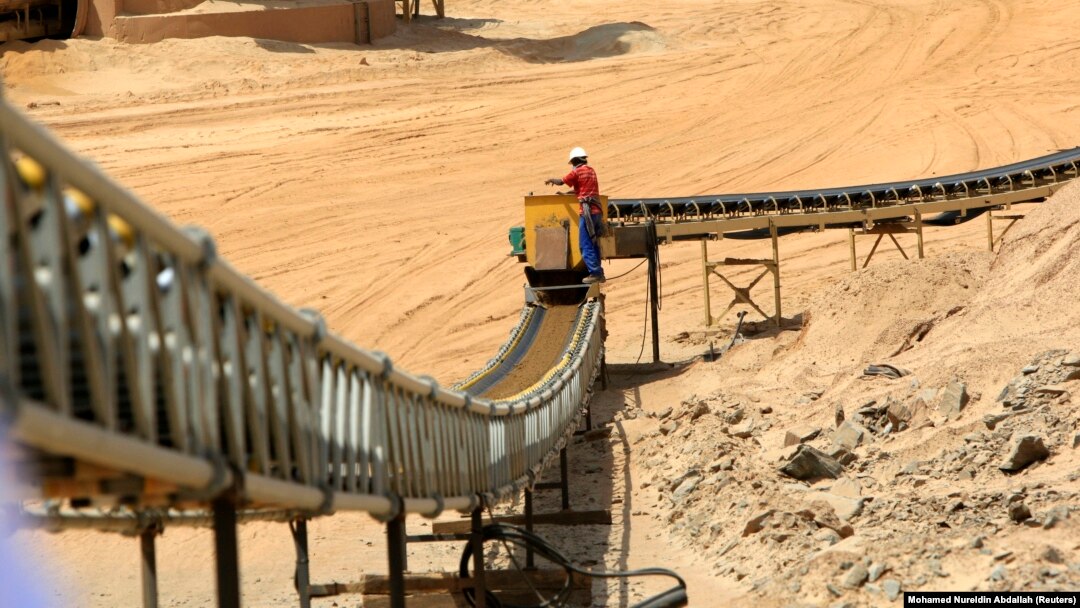 Seorang pekerja berfoto di samping ban berjalan di tambang Sudan, 28 September 2011. (Foto: REUTERS/Mohamed Nureldin Abdallah)