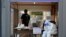 A health official wearing protective gear takes a rest during the COVID-19 testing at a public health center in Goyang, South Korea, May 28, 2020. 