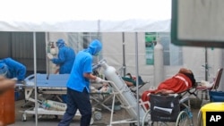  A medical worker wheels an oxygen tank to be used to treat patients at an emergency tent erected to accommodate a surge in COVID-19 cases, at Dr. Sardjito Central Hospital in Yogyakarta, Indonesia, Sunday, July 4, 2021.