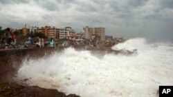 Warga menyaksikan ombak besar di pesisir Teluk Benggala di Vishakhapatnam, India (12/10). 