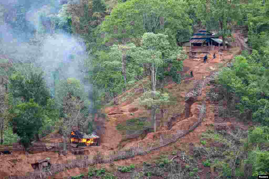 Ethnic minority Karen troops are seen after setting fire to a building at a Myanmar army outpost near the Thai border, which is seen from the Thai side along the Thanlwin River in Mae Hong Son province, Thailand.