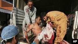 A man who is injured in a twin suicide bomb in Charsadda, is carried out from a vehicle after being brought to Lady Reading hospital in Peshawar, May 13, 2011