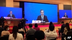 On May 24, 2020, file photo, China's Foreign Minister Wang Yi is seen broadcasted remotely on big screens at the media center during a press conference held on the sideline of the National People's Congress in Beijing.