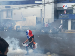 Los manifestantes se dispersan en medio de los gases lacrimógenos lanzados por la policía en San José, Costa Rica, el 12 de octubre de 2020.