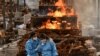 Anggota keluarga Vijay Raju, yang meninggal karena COVID-19, berkabung sebelum dikremasi di tempat krematorium di desa Giddenahalli di pinggiran Bengaluru, India, 13 Mei 2021. (Foto: REUTERS/Samuel Rajkumar)