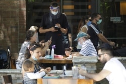 A waiter takes a food order July 18, 2020, in Burbank, Calif.