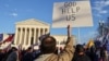 Arhiva: Čovjek drži parolu "Pomozi nam Bože tokom protesta zbog izbornih rezultata, ispred zgrade Vrhovnog suda SAD u Washingtonu, 12. decembra 2020.