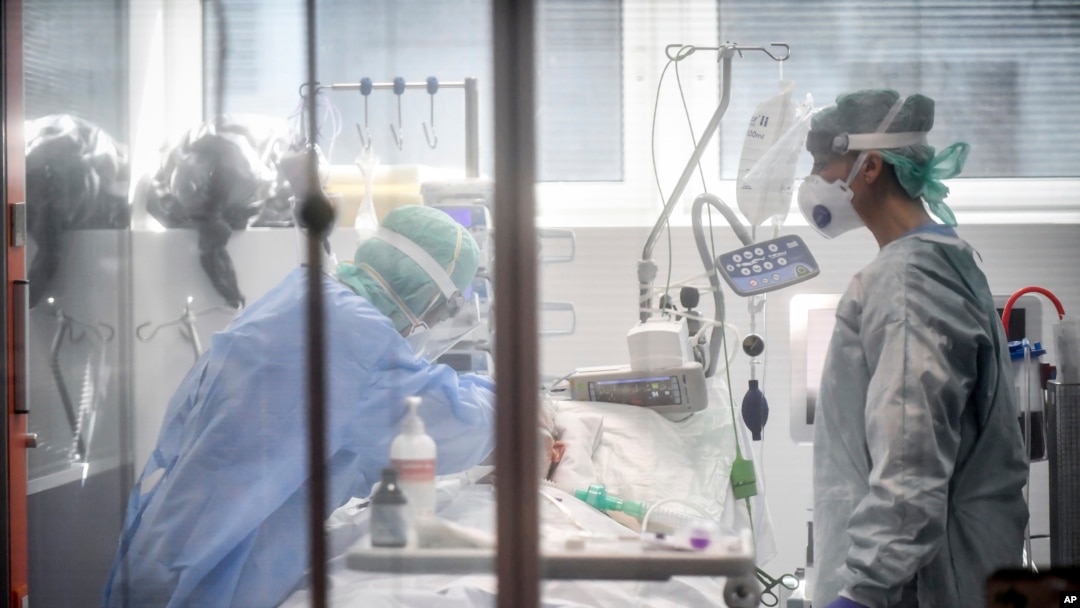 FILE - Medical personnel work in the intensive care unit of a hospital in Brescia, Italy, March 19, 2020.