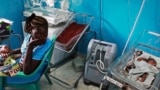 FILE - A woman holding her baby in a nursery watches another newborn who is attached to a ventilator at Juba Teaching Hospital in Juba, April 3, 2013. South Sudan has one of the highest maternal mortality rates in the world.