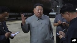 En esta imagen sin fecha, distribuida el 23 de julio de 2019 por el gobierno de Corea del Norte, el líder del país, Kim Jong Un (centro), habla mientras inspecciona un submarino recién construido en una localización no revelada de Corea del Norte.