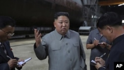 En esta imagen de archivo, el líder norcoreano Kim Jong Un conversa con los periodistas durante una inspección de un nuevo submarino en Corea del Norte.