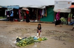 FILE - A Rohingya refugee girl sells vegetables in Kutupalong refugee camp, Bangladesh, Aug. 28, 2018.