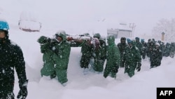 In this handout photo taken and released by the State Disaster Response Force (SDRF) on Feb 28, 2025, rescuers carry Border Roads Organisation (BRO) workers after an avalanche near Mana village in Chamoli district, India.