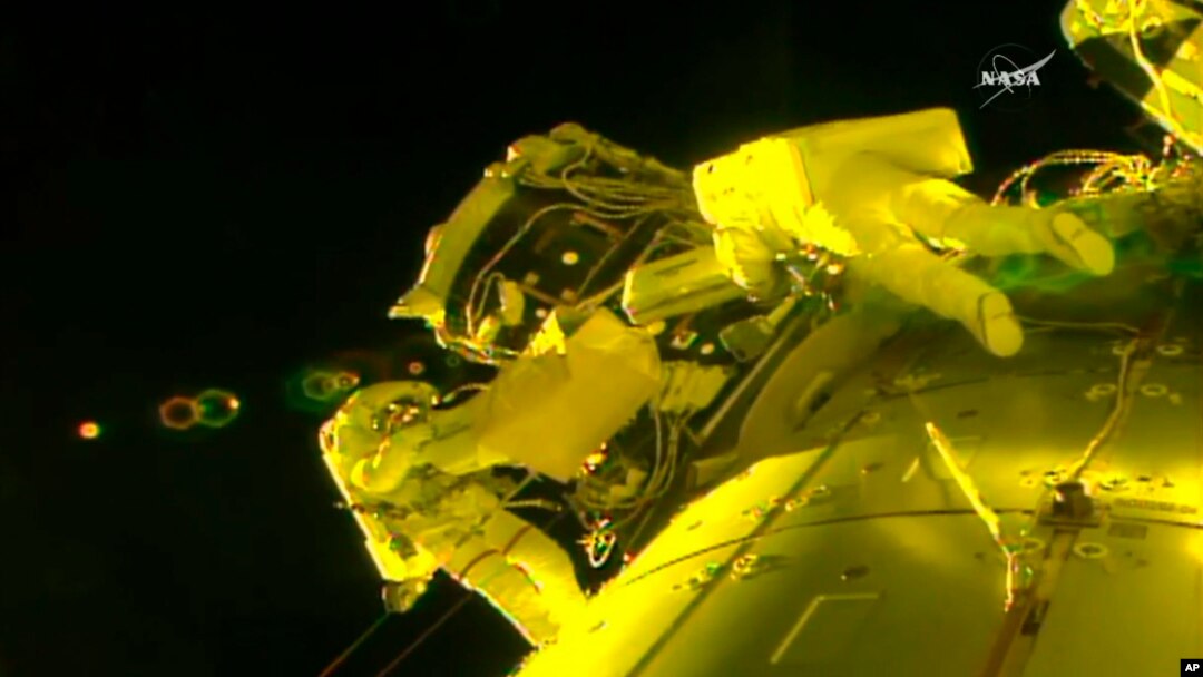 In this image made from video provided by NASA, U.S. astronauts Shane Kimbrough, left, and Peggy Whitson, install a shield on a relocated docking port outside of the International Space Station, March 30, 2017.