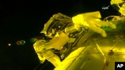 In this image made from video provided by NASA, U.S. astronauts Shane Kimbrough, left, and Peggy Whitson, install a shield on a relocated docking port outside of the International Space Station, March 30, 2017.