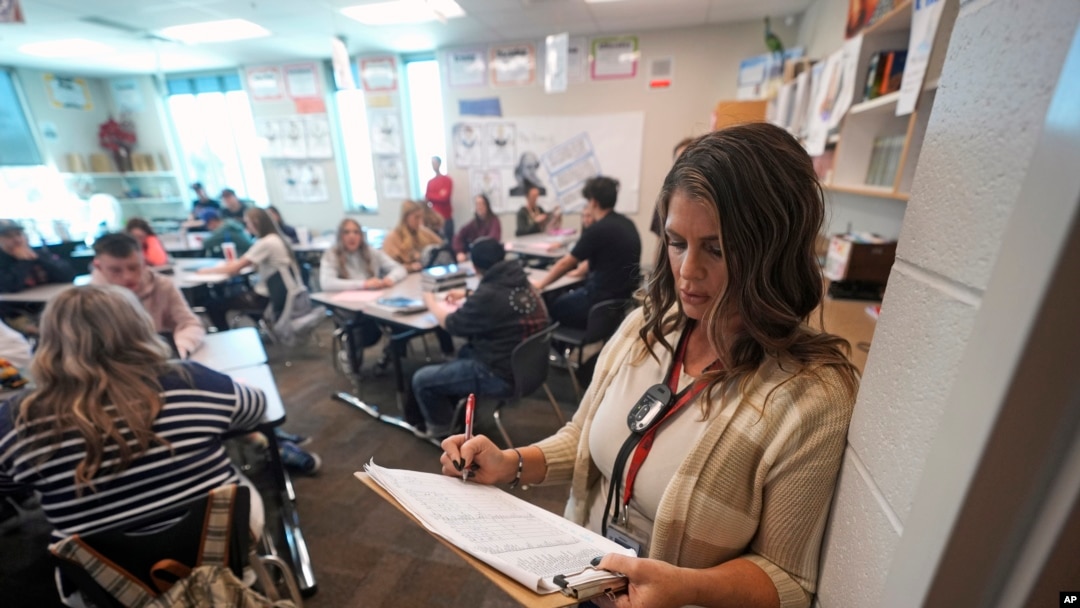 Kelli Anderson takes attendance from the rear of her Language Arts 9 class at Delta High School, Friday, Feb. 23, 2024, in Delta, Utah. At the rural Utah school, there is a strict policy requiring students to check their phones at the door when entering every class.