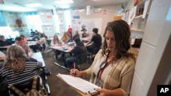 Kelli Anderson takes attendance from the rear of her Language Arts 9 class at Delta High School, Friday, Feb. 23, 2024, in Delta, Utah. At the rural Utah school, there is a strict policy requiring students to check their phones at the door when entering every class.
