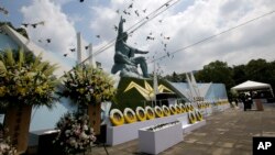 FILE - Doves fly over the Peace Statue during a ceremony to mark the 70th anniversary of the atomic bombing in Nagasaki, southern Japan, Aug. 9, 2015. 