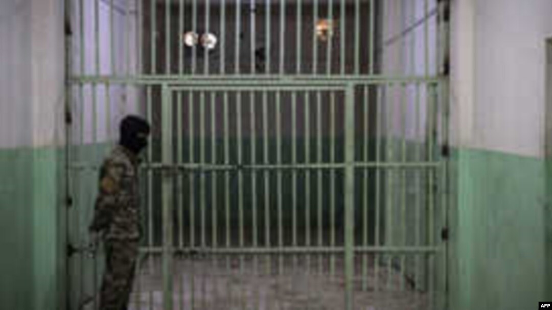 FILE - A member of the U.S.-backed Syrian Democratic Forces (SDF) stands guard in a prison where men suspected to be afiliated with the Islamic State (IS) group are jailed in northeast Syria in the city of Hasakeh on October 26, 2019. 