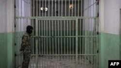 FILE - A member of the U.S.-backed Syrian Democratic Forces (SDF) stands guard in a prison where men suspected to be afiliated with the Islamic State (IS) group are jailed in northeast Syria in the city of Hasakeh on October 26, 2019. 