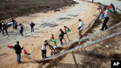 Palestinian activists use ladders to cross over the Israeli separation barrier to pray on Friday at the al-Aqsa Mosque in the Old City of Jerusalem, Nov. 14, 2014. 