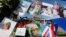 FILE - Pictures and flags marking the 20th anniversary of the death of Diana, Princess of Wales, hang on the gates of Kensington Palace in London, Aug. 31, 2017. 
