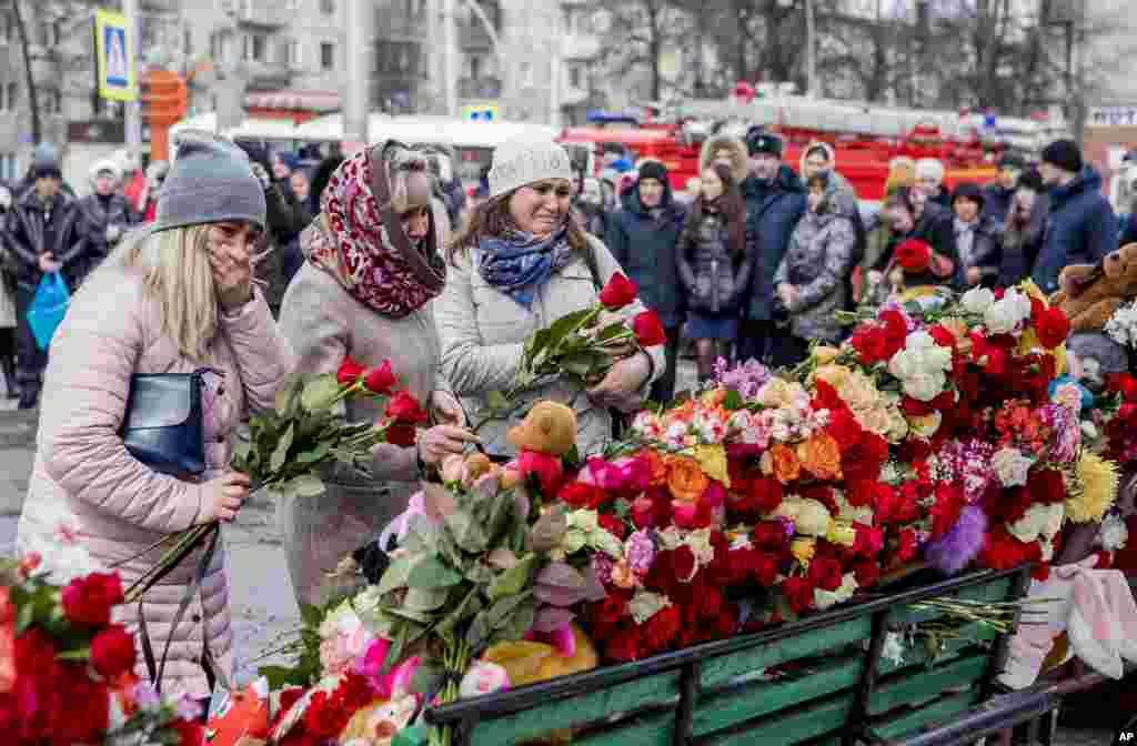 People lay flowers for the victims of a fire in a multi-story shopping center in the Siberian city of Kemerovo, about 3,000 kilometers (1,900 miles) east of Moscow, Russia.