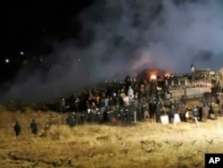 FILE - In this Nov. 20, 2016 file photo, provided by Morton County Sheriff's Department, law enforcement and protesters clash near the site of the Dakota Access pipeline in Cannon Ball, N.D.