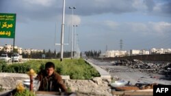 Umunyasiriya kw'ibarabara rija ku kibuga c'indege c'i Aleppo, kw'itariki ya 28/03/2013