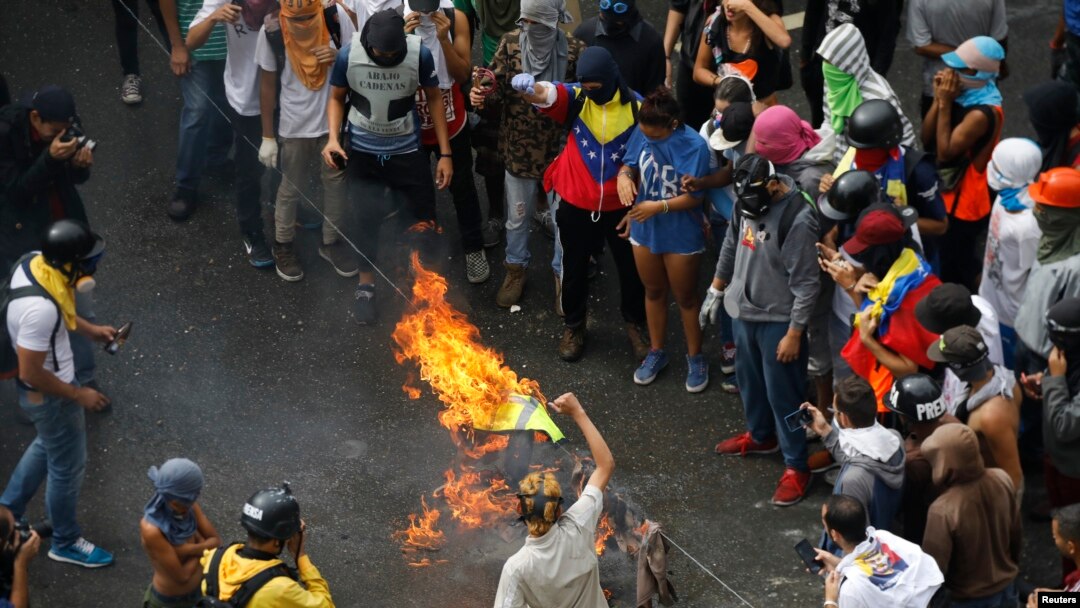 Demonstran membakar barikade saat bentrok dengan petugas keamanan sementara pemilu sedang berlangsung di Caracas, Venezuela, 30 Juli 2017.