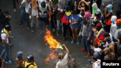 Demonstran membakar barikade saat bentrok dengan petugas keamanan sementara pemilu sedang berlangsung di Caracas, Venezuela, 30 Juli 2017.