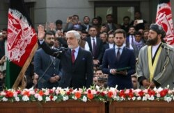 Afghanistan's Abdullah Abdullah, front left, greets supporters after being sworn in as president in an inauguration competing with that of President Ashraf Ghani, in Kabul, Afghanistan, March 9, 2020.