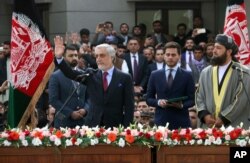 Afghanistan's Abdullah Abdullah, front left, greets supporters after being sworn in as president in an inauguration competing with that of President Ashraf Ghani, in Kabul, Afghanistan, March 9, 2020.