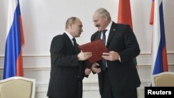 Presiden Belarus Alexander Lukashenko (kanan) dan Presiden Rusia Vladimir Putin dalam penandatanganan kerjasama di Minsk (31/5). Putin menjanjikan dukungan moral dan pinjaman dana bagi Belarus. 