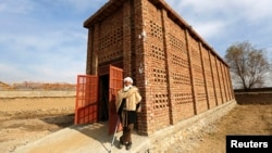 Afghan farmer Mohammad Malik stands outside his grape pitfall, a U.S. Agency for International Development project in Parwan province, Dec. 13, 2014. International aid has long been the mainstay of the Afghan economy.