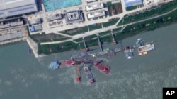 FILE - This satellite image from Planet Labs PBC shows what appears to be a sunken Chinese submarine at a shipyard near Wuhan, China, June 15, 2024.